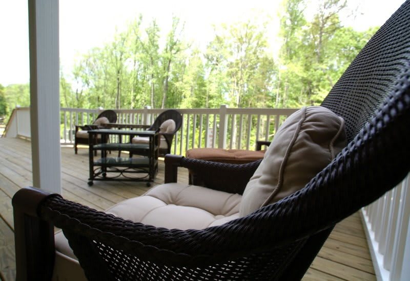 Cozy outdoor seating area on a deck surrounded by nature.