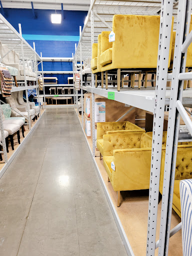 A well-organized furniture store aisle showcasing vibrant yellow chairs.