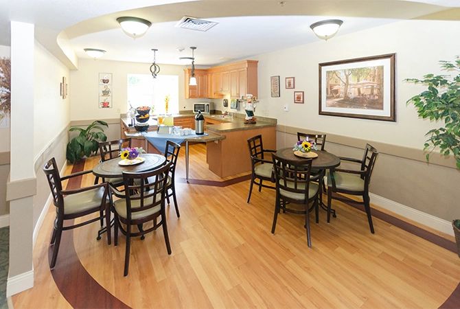 An inviting kitchen and dining area with wooden flooring and neatly arranged furniture.