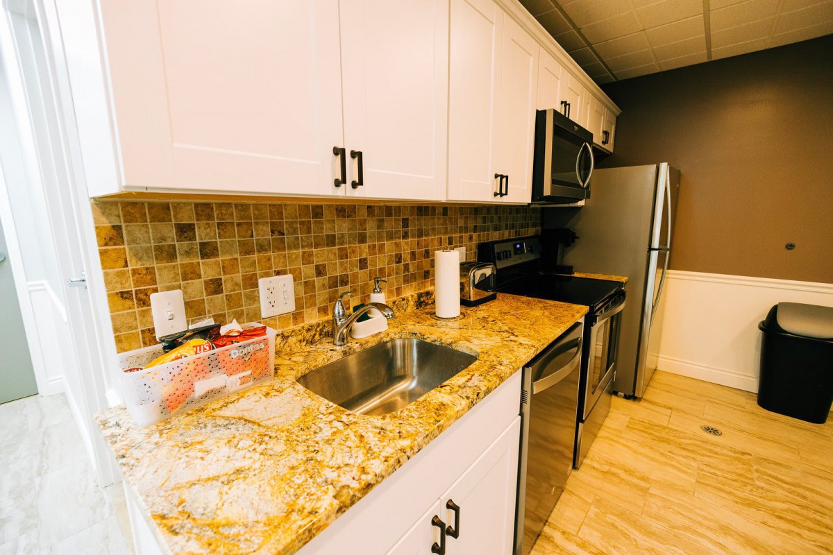 A modern kitchen with granite countertops and stainless steel appliances.