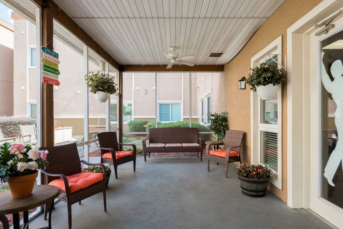 A cozy porch with comfortable seating and hanging plants.