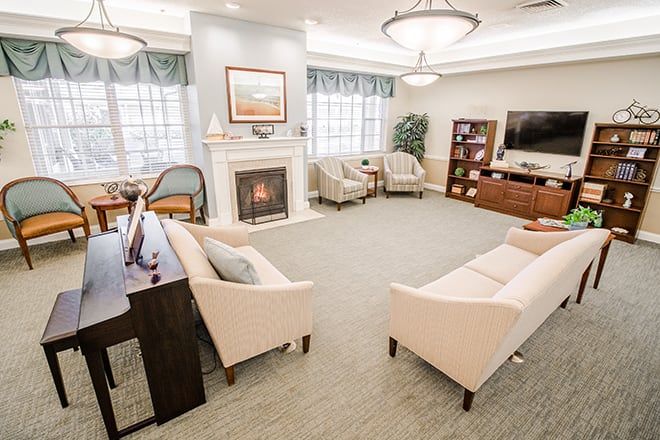 A cozy and modern living room with a fireplace, comfortable seating, and a television.