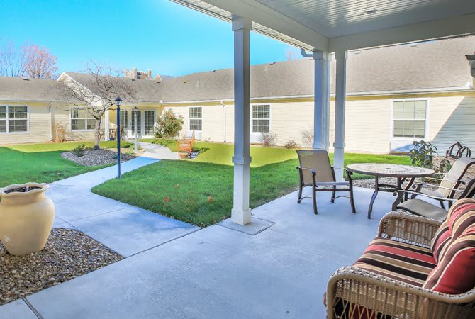 A cozy backyard patio with outdoor seating and a well-maintained lawn.