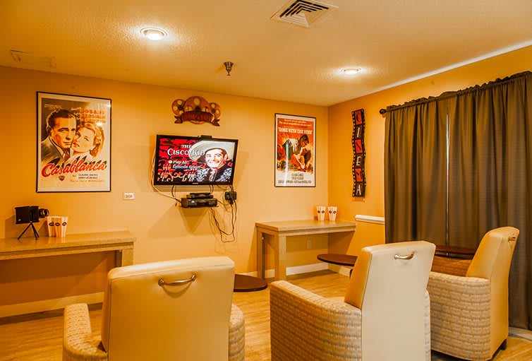 A cozy lounge with comfortable seating and a television, decorated with vintage posters.