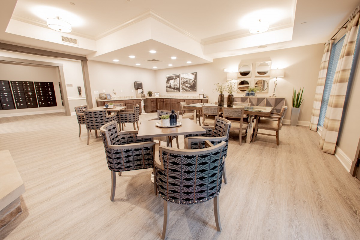 A modern dining area with wicker chairs and wooden tables, complemented by stylish lighting.