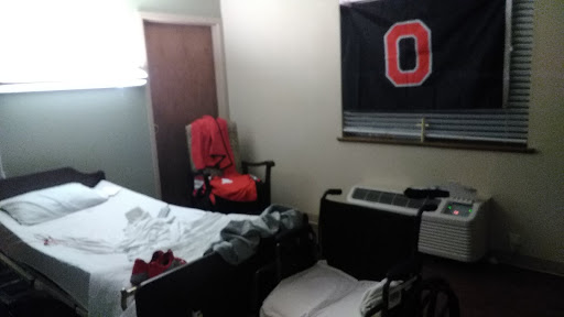 A cozy but cluttered bedroom featuring a flag and messy bedding.