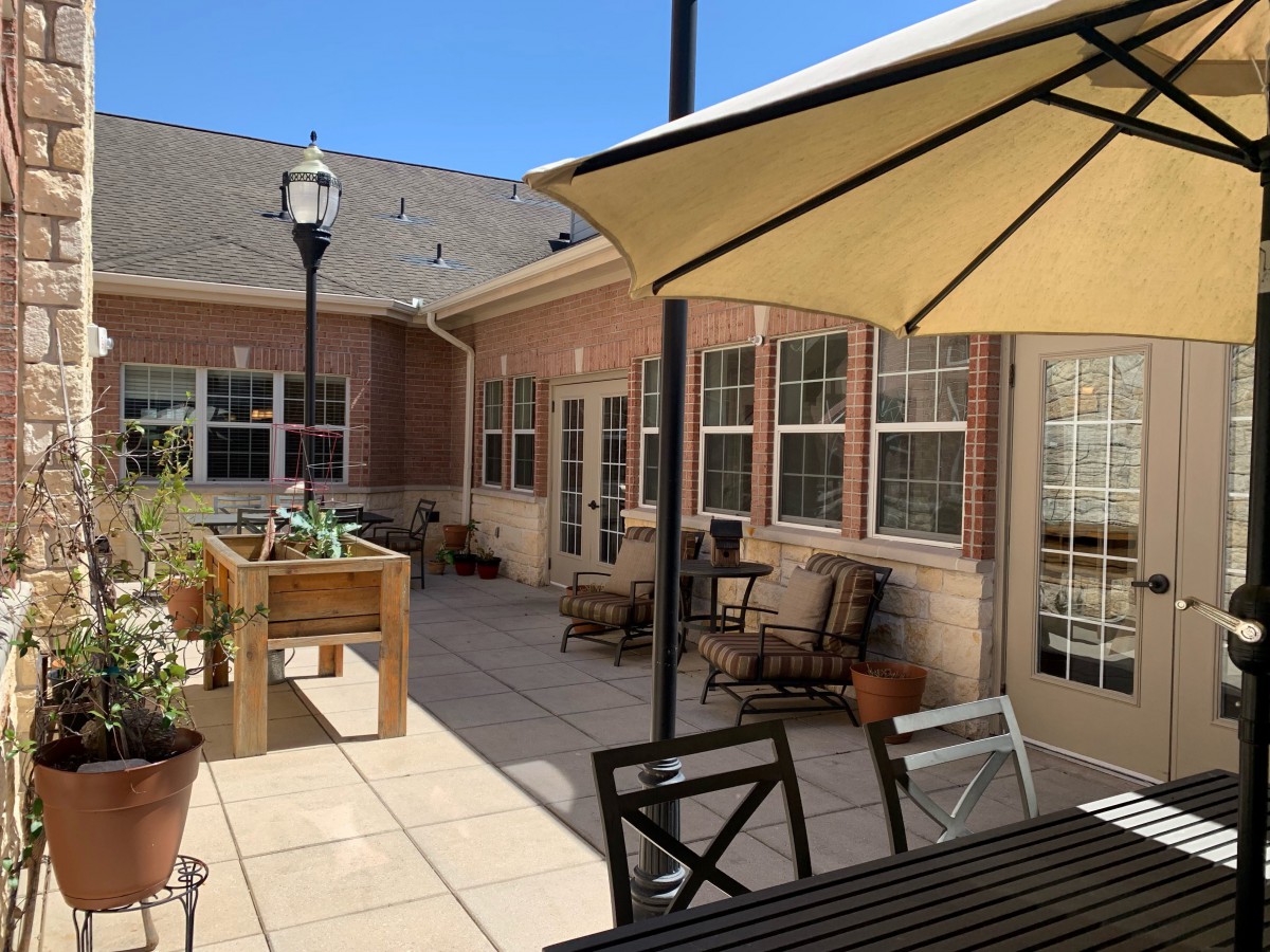 A sunny patio with outdoor furniture and plants.
