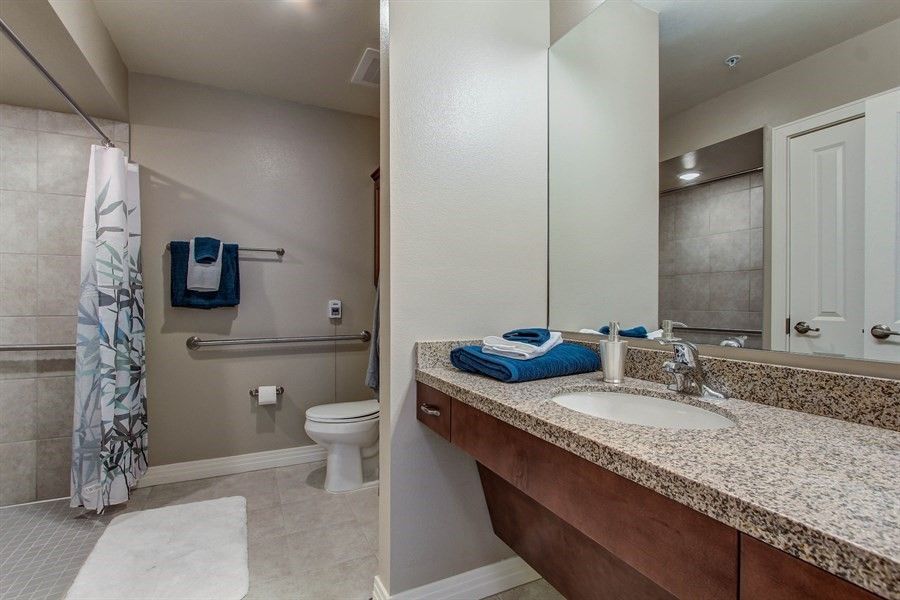 Modern bathroom with a sink, mirror, and neatly arranged towels.