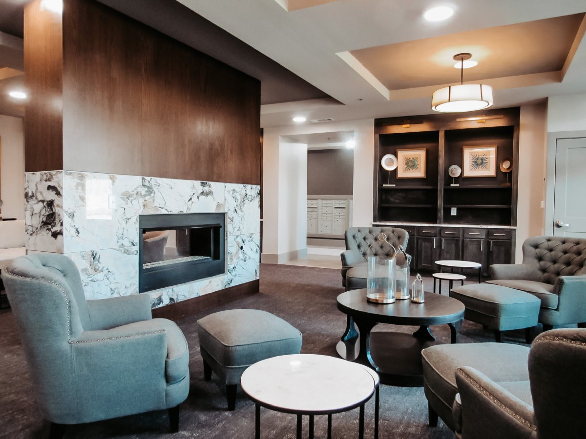 A modern living room with a cozy fireplace and elegant seating area.