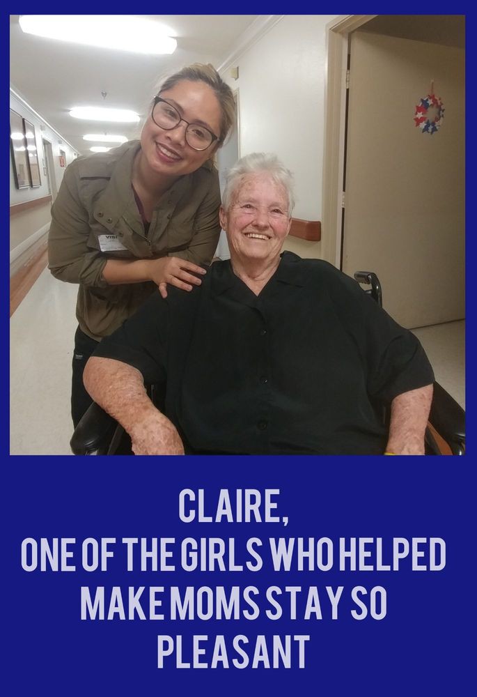 A caregiver and an elderly woman smiling together in a nursing home.