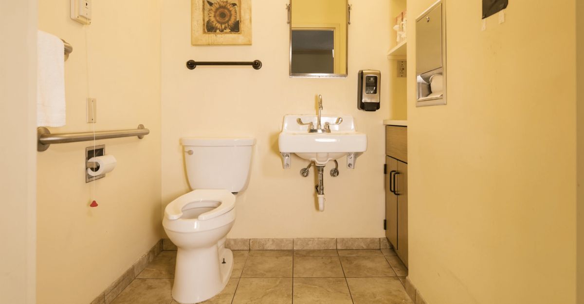 A clean and organized bathroom with a toilet, sink, and mirror.