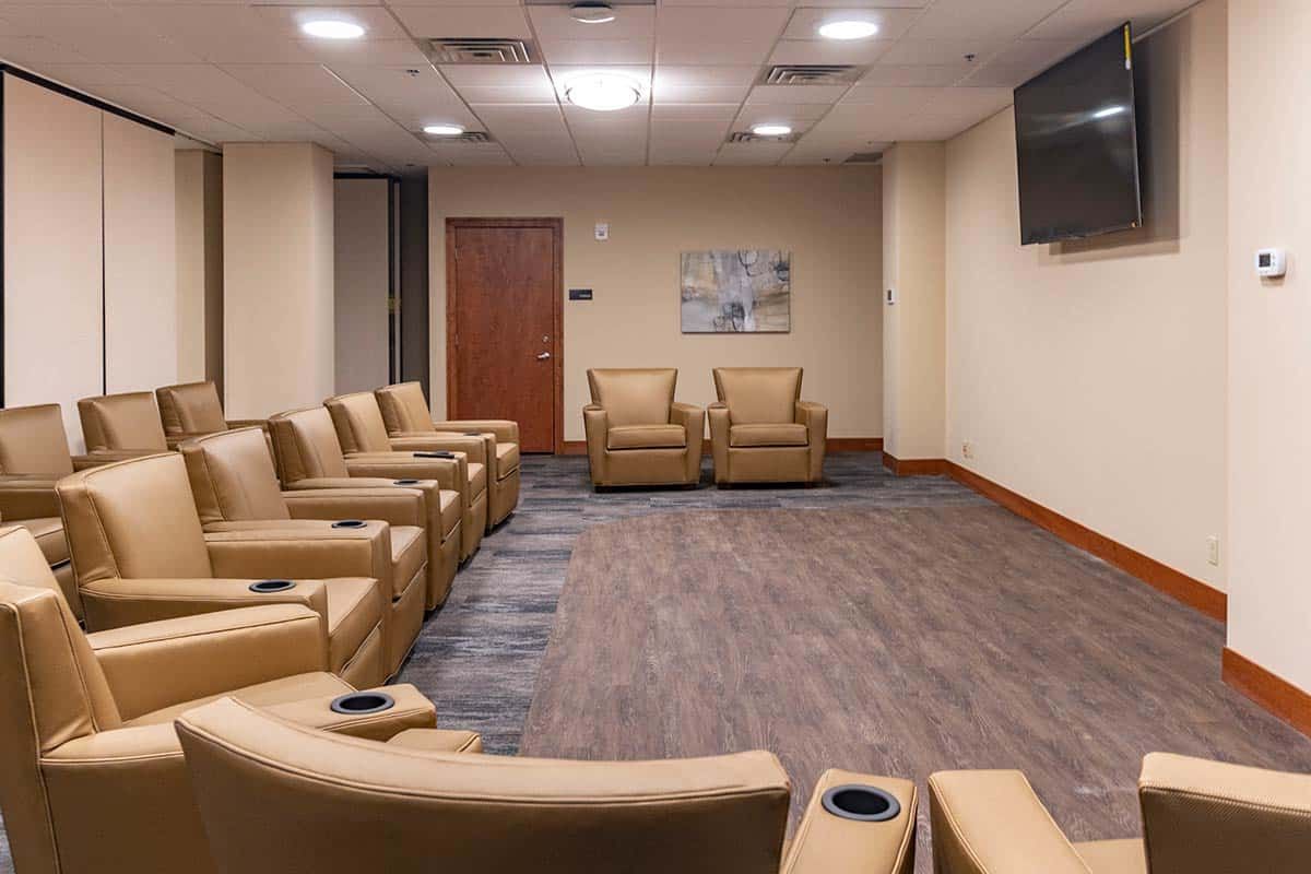 A modern waiting room with comfortable armchairs and a television.