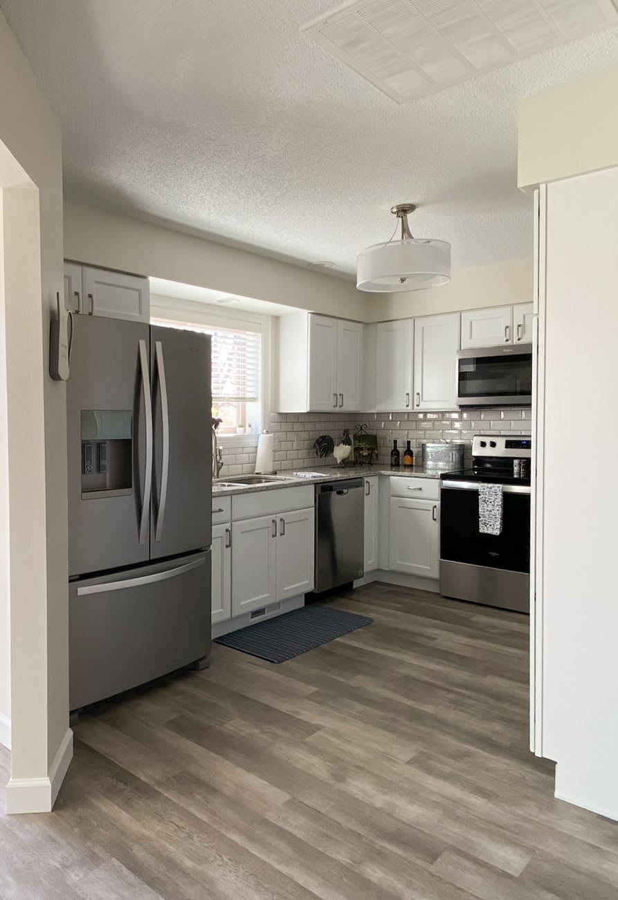 A modern kitchen with stainless steel appliances and white cabinets.