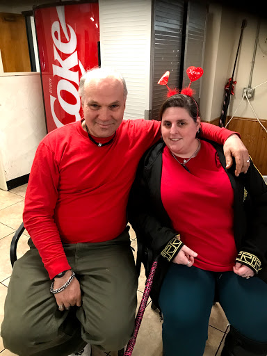 Two individuals dressed in red, enjoying a cheerful moment together.