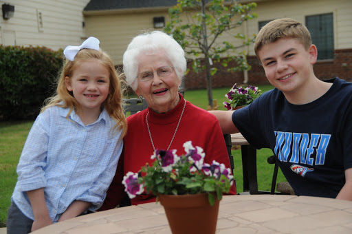 A joyful moment shared between a grandmother and her grandchildren in a beautiful outdoor setting.