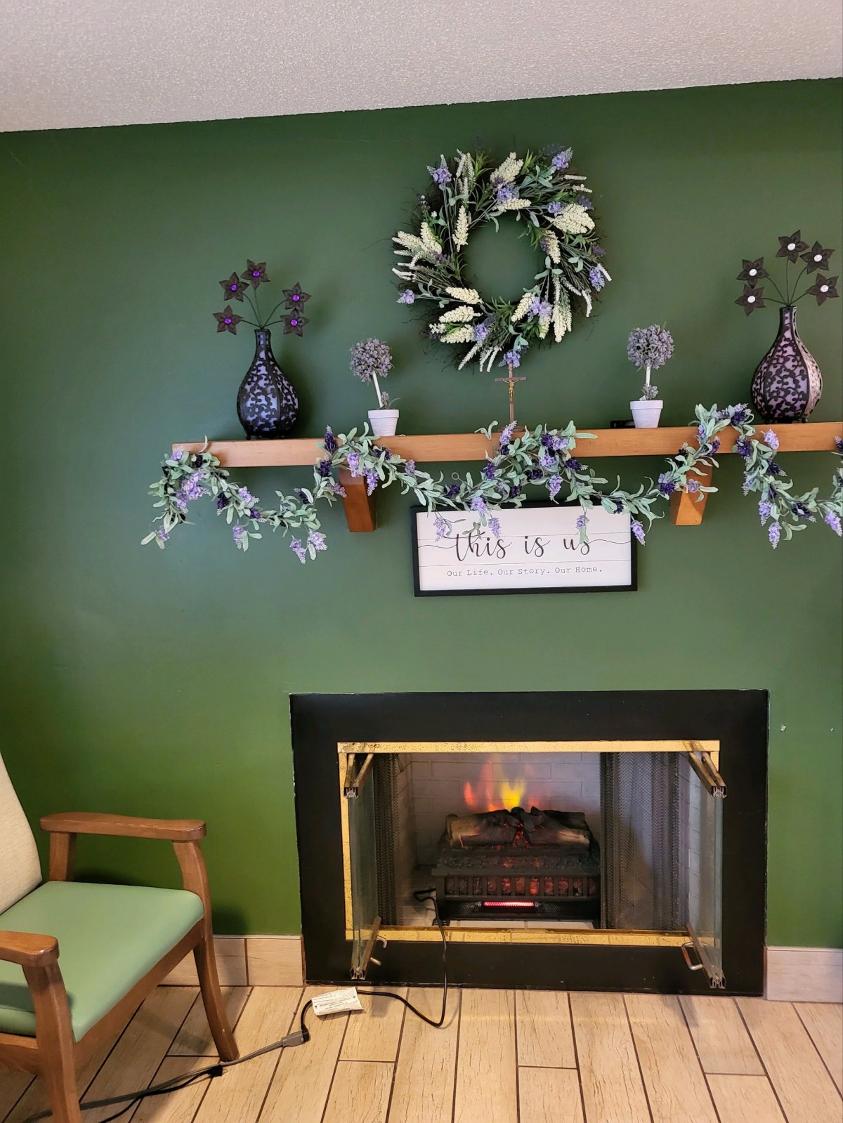A cozy living room with a decorated mantel and a warm fireplace.