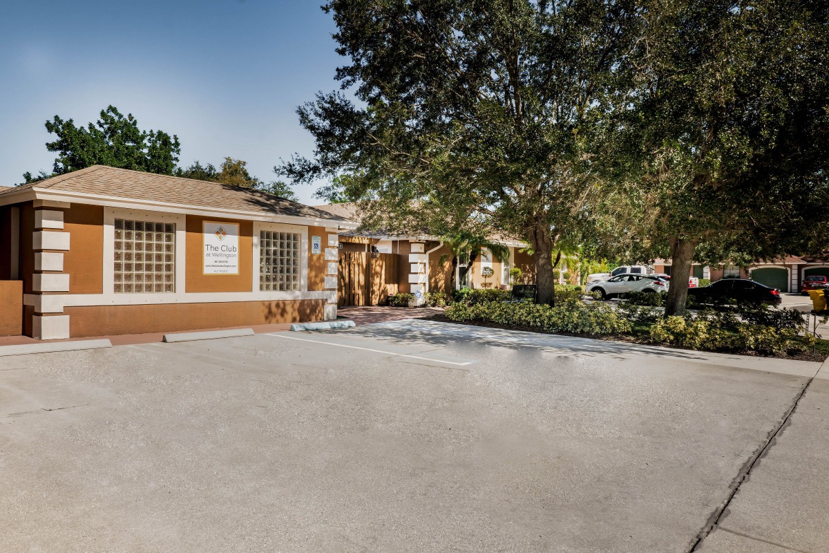 A suburban house with a driveway and surrounding trees.
