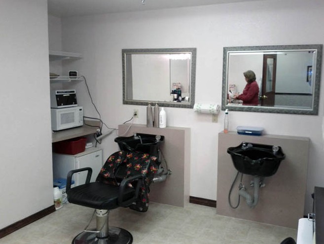 An interior view of a barbershop with chairs and mirrors.