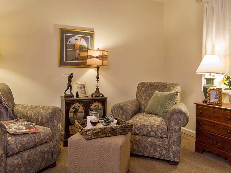 A cozy living room with patterned armchairs, soft lighting, and decorative accents.
