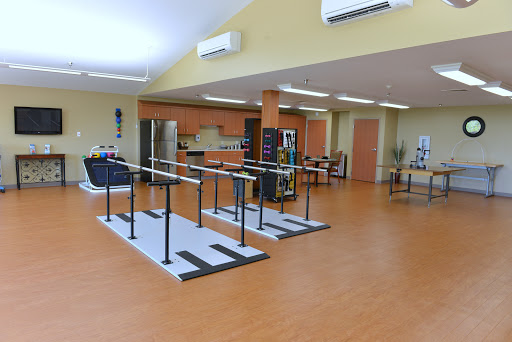 A spacious therapy room equipped with ballet bars and exercise equipment, designed for rehabilitation activities.