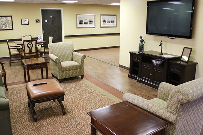 A cozy lobby area with comfortable seating and a large television.