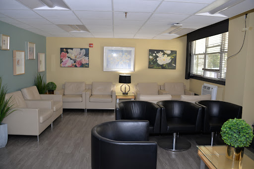 A cozy waiting room featuring comfortable seating, modern decor, and artwork on the walls.