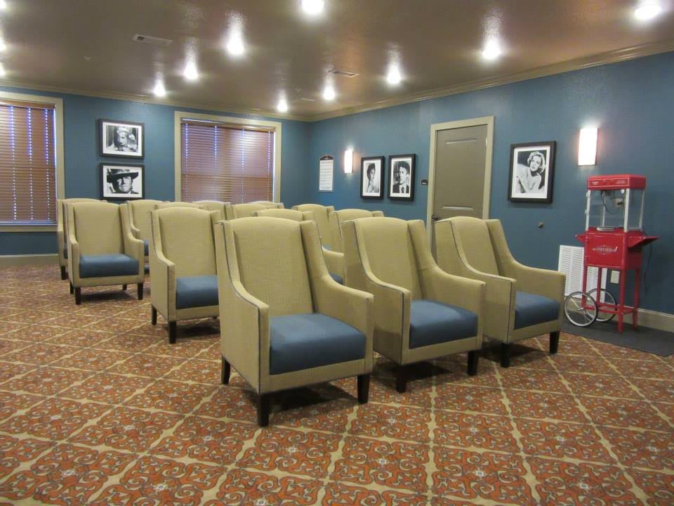 An empty movie theater with comfortable seating and framed pictures on the walls.