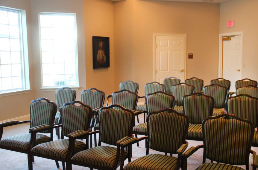 An empty conference room with rows of patterned chairs arranged neatly.