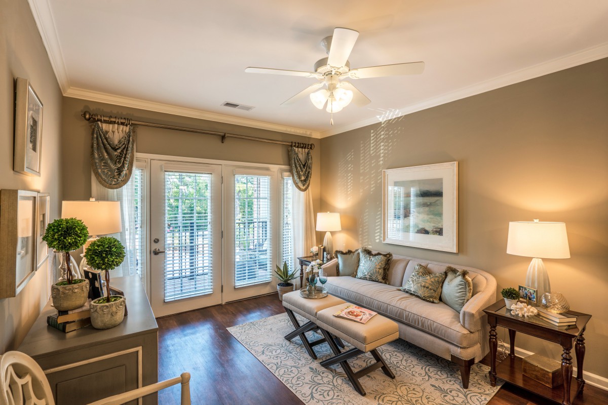 A cozy and elegantly furnished living room with large windows, a comfortable couch, and decorative elements.