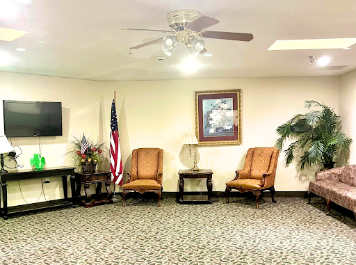 A cozy waiting room featuring comfortable chairs, a television, and decorative elements.