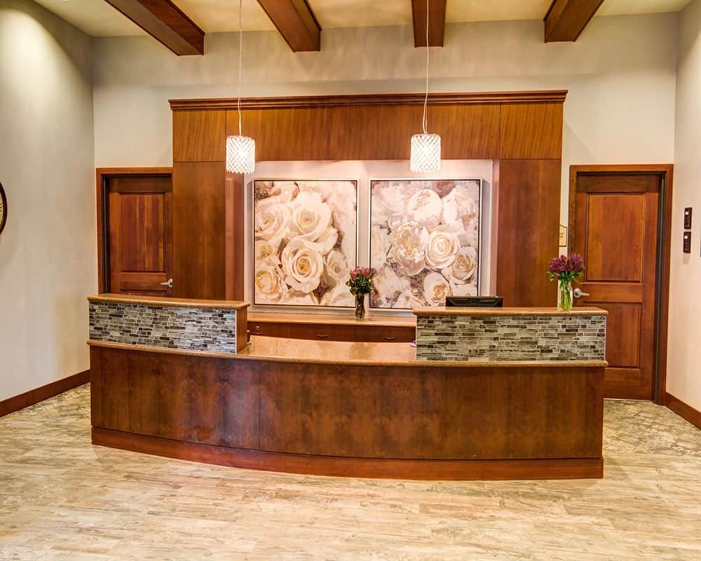 A well-appointed hotel reception area featuring wood paneling and decorative lighting.