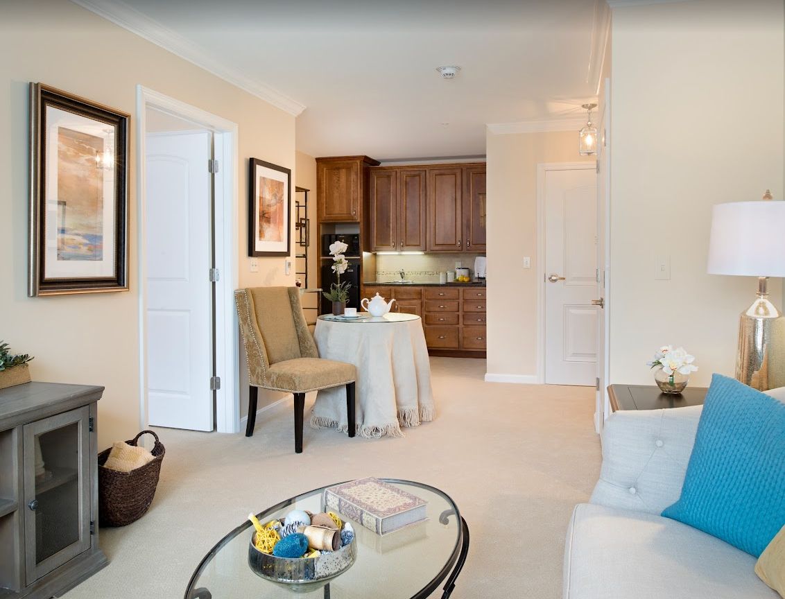 A cozy living room with a small dining table leading into a compact kitchen.