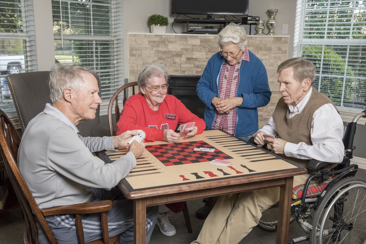 A group of seniors enjoying a card game together indoors.