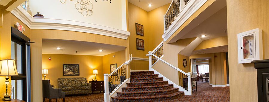 A cozy interior featuring a carpeted staircase and warmly decorated living area.