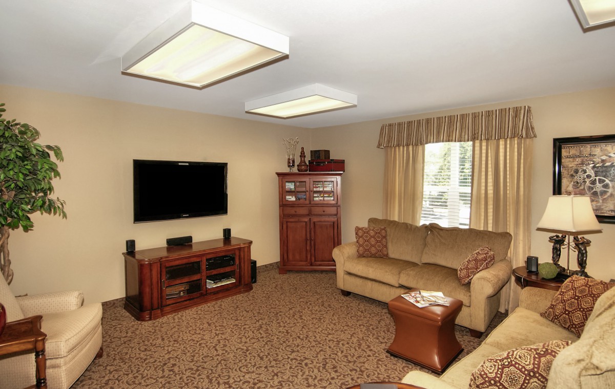 A cozy living room with a sofa, television, and cabinet.