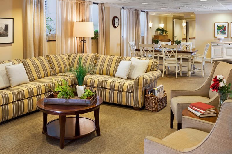 A cozy living room with a striped sofa and a coffee table, featuring elegant interior design elements.
