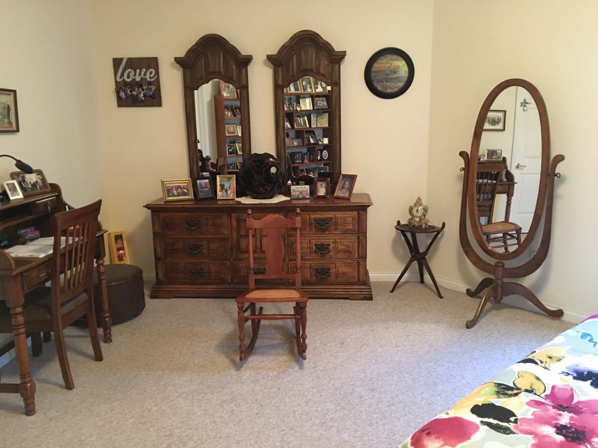 A cozy bedroom with vintage wooden furniture and mirrors.