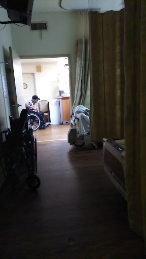 A glimpse into a hospital room showing a patient in a wheelchair.