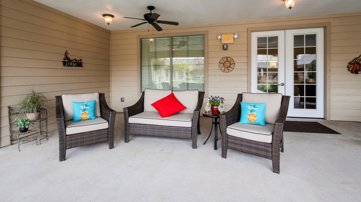 A cozy outdoor patio with wicker furniture and colorful cushions.