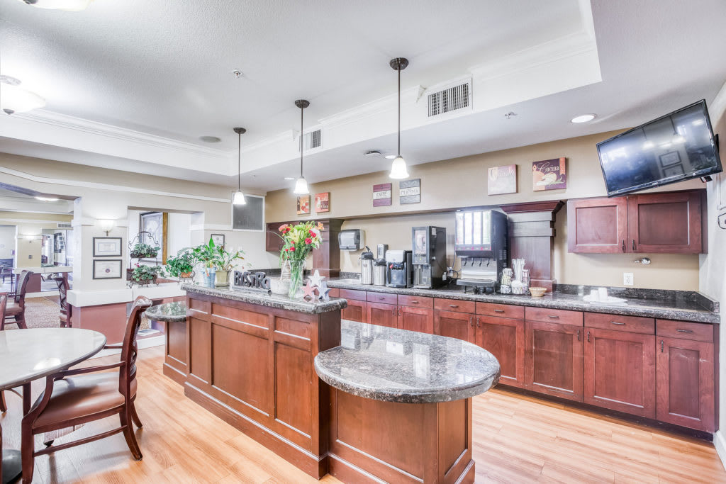 A modern kitchen with wooden cabinets, a central island, and pendant lighting.