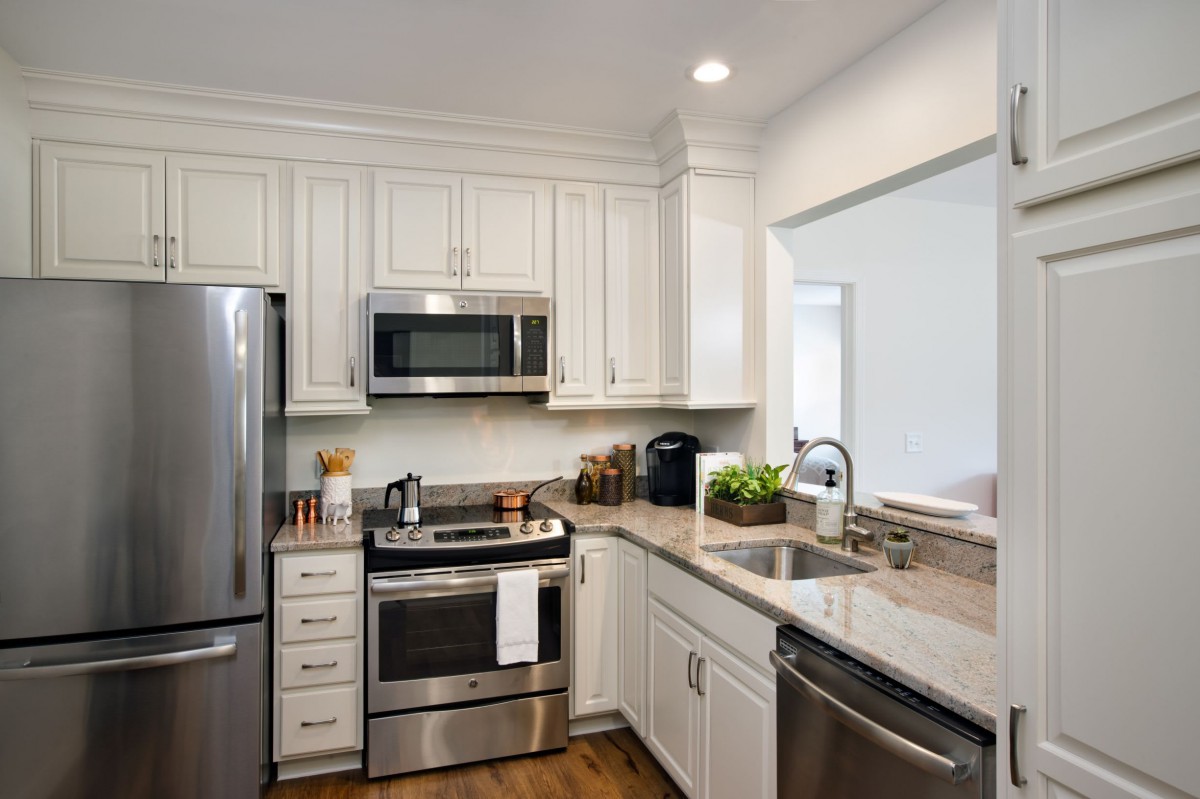 A modern kitchen with stainless steel appliances and white cabinets.