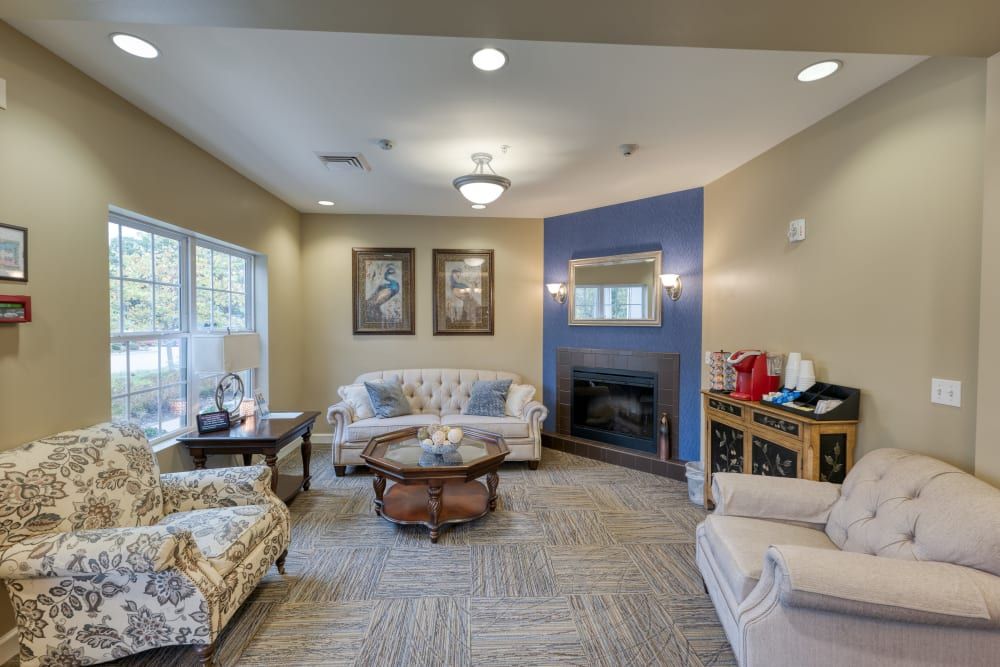 A cozy living room with a sofa set, coffee table, fireplace, and decorative artwork.
