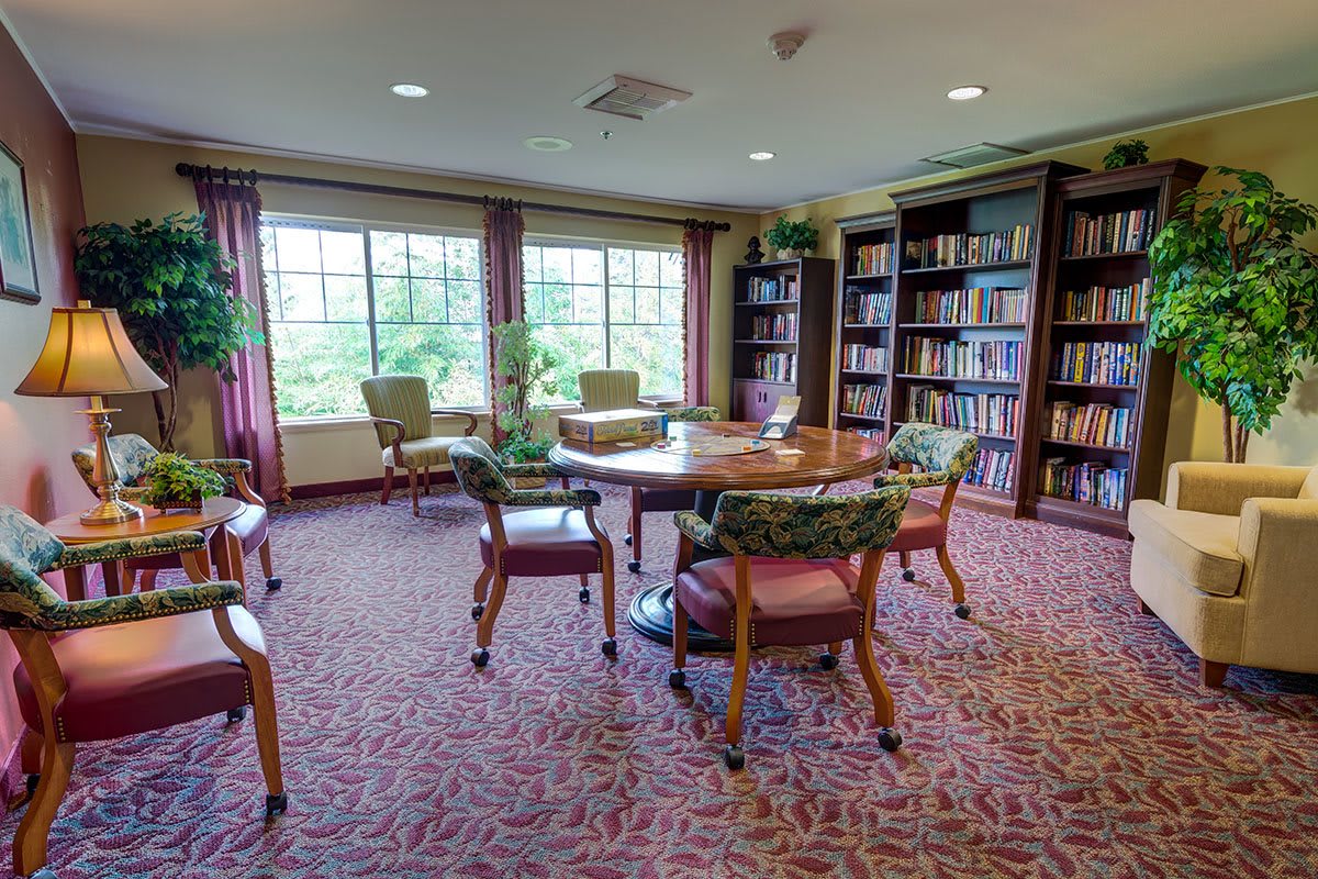 A cozy library reading room with bookshelves and comfortable seating.