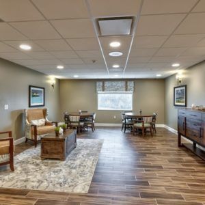 A cozy indoor lounge area with comfortable seating, wooden flooring, and wall decorations.