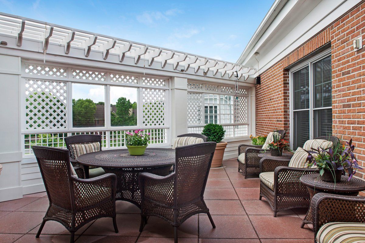 A cozy outdoor patio with seating arrangements under a pergola.