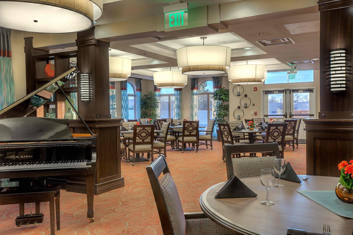 An elegant restaurant dining area with neatly arranged tables and chairs, complemented by tasteful lighting and decor.