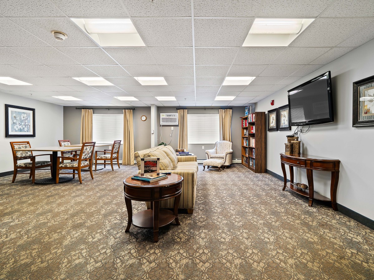 A spacious and well-lit living room with comfortable seating, a large television, and stylish decor.
