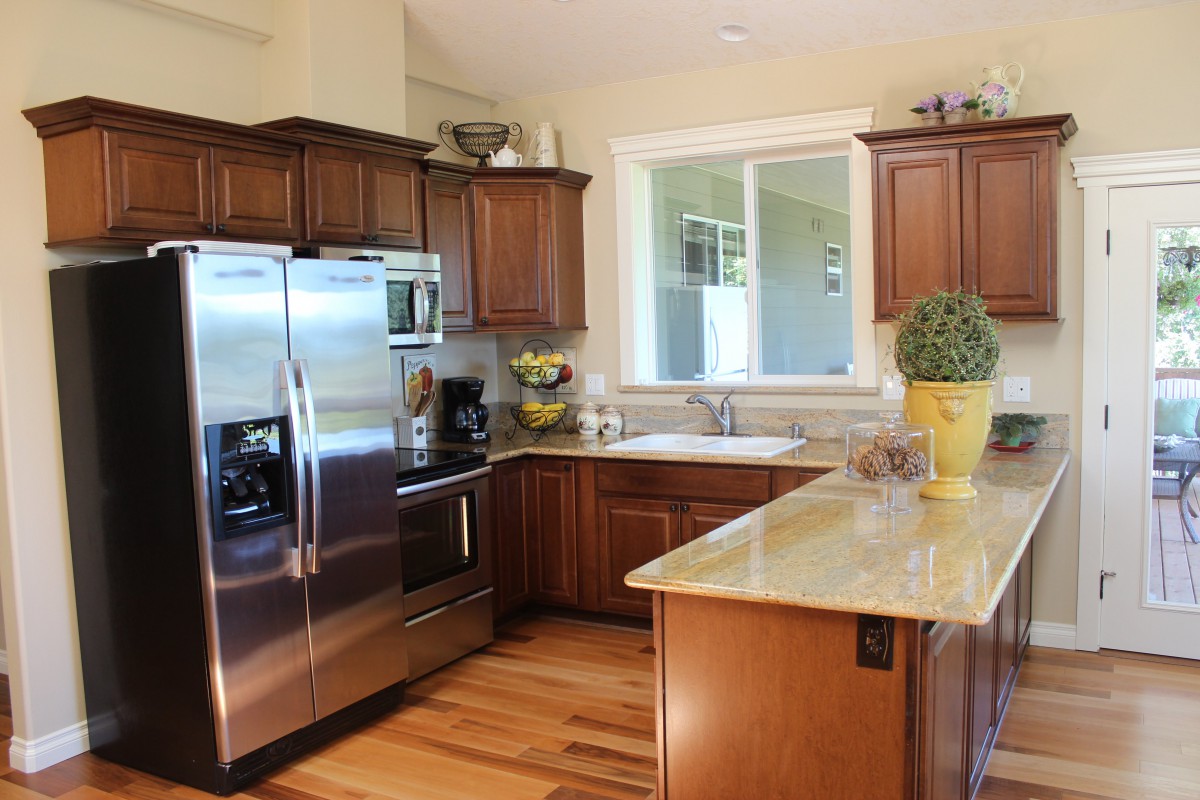 A modern kitchen with wood cabinets and stainless steel appliances.