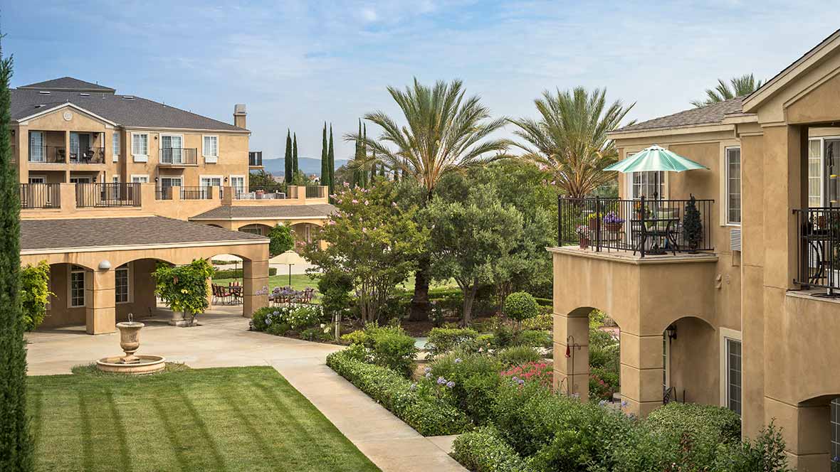 A beautiful outdoor garden with palm trees and elegant architecture.