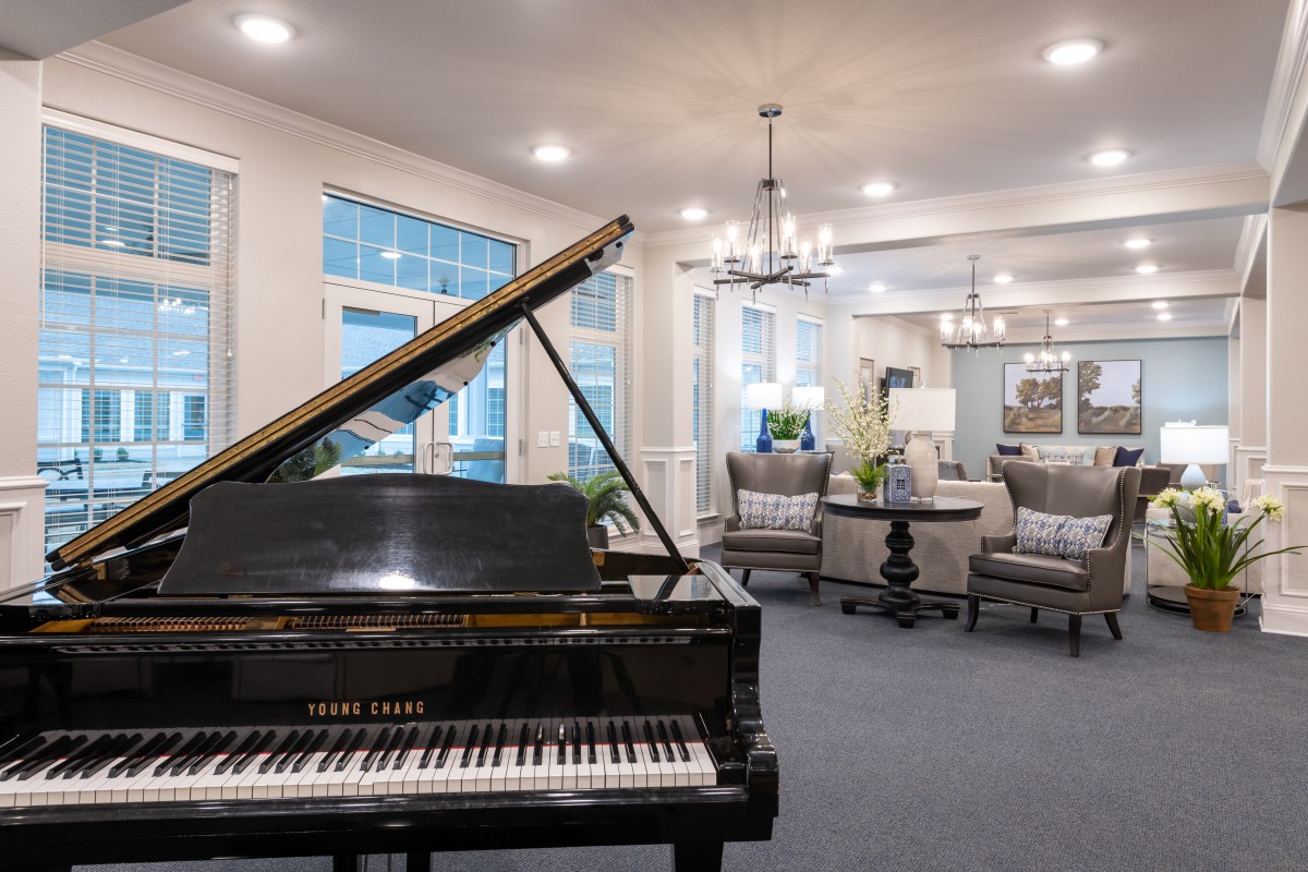 A modern living room featuring a grand piano and elegant furnishings.